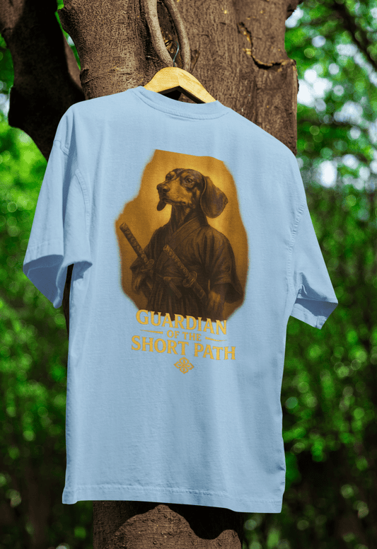 Hellblaues T-Shirt mit Dackel-Motiv Guardian-of-the-Short-Path im Fantasy-Illustration-Stil für Hundeliebhaber.