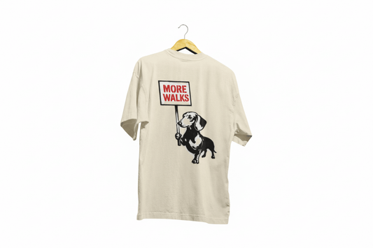 Beiges T-Shirt mit Dackel-Motiv und Schriftzug More-Walks im Banksy-inspirierten Street-Art-Stil für Hundefreunde.