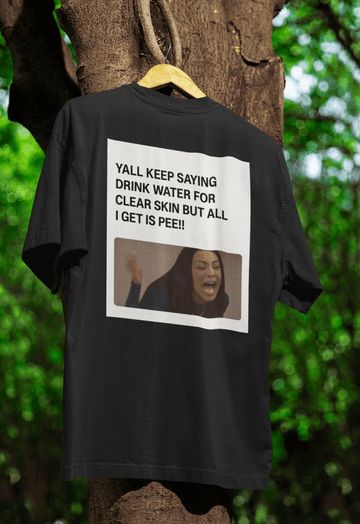 Schwarzes T-Shirt mit Schriftzug Yall-Keep-Saying-Drink-Water-For-Clear-Skin-But-All-I-Get-Is-Pee und Meme-Bild im Barbie-Meme-Stil für Humorvolle.