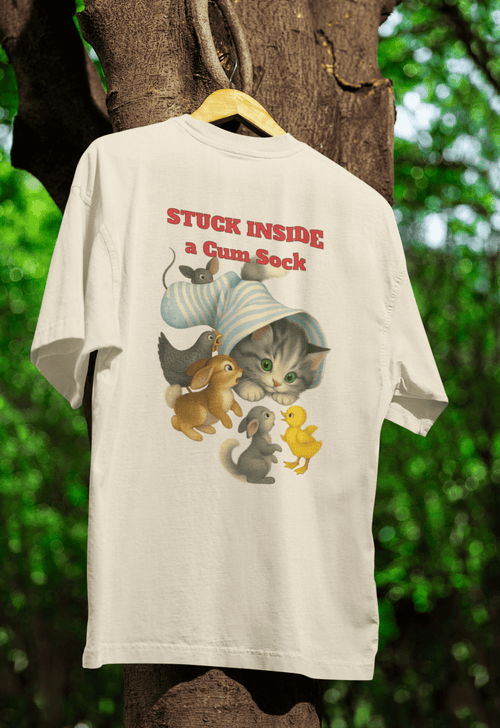 Cremefarbenes T-Shirt mit Schriftzug Stuck-Inside-a-Gum-Sock und Katze im Kinderbuch-Illustrationsstil fuer Tierfreunde.