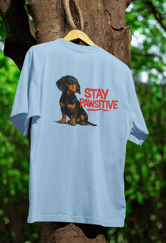 Hellblaues T-Shirt mit Dackel und Schriftzug Stay-Pawsitive im Street-Art-Graffiti-Stil fuer Hundeliebhaber. True Insights.