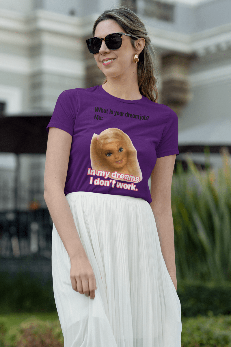 Violettes T-Shirt mit Schriftzug Was-ist-dein-Traumjob und Barbie-Illustration im Barbie-Meme-Stil fuer Frauen mit Work-Life-Ironie.