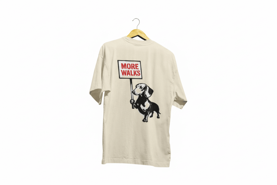 Beiges T-Shirt mit Dackel-Motiv und Schriftzug More-Walks im Banksy-inspirierten Street-Art-Stil für Hundefreunde.