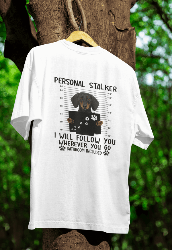 Weißes T-Shirt mit Schriftzug Personal-Stalker und Dackel-Mugshot im Comic-Stil für Hundeliebhaber.