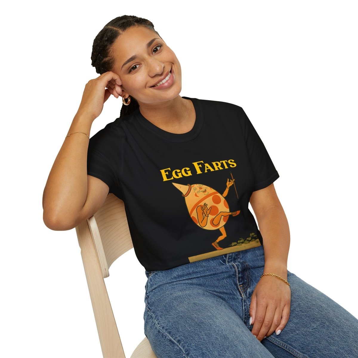 Schwarzes T-Shirt mit orange-gelbem Ei-Charakter in surrealer Retro-Kinderbuch-Satire von True Insights.