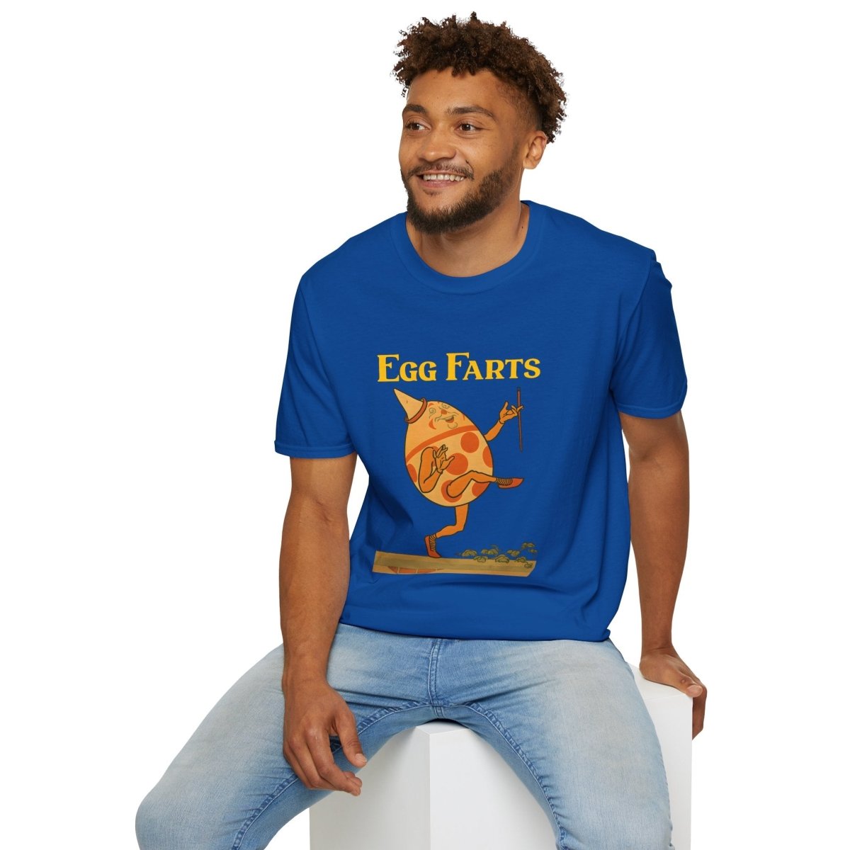 Blaues T-Shirt mit Retro Kinderbuch-Satire Ei-Charakter und goldener Egg Farts Schriftzug, True Insights.