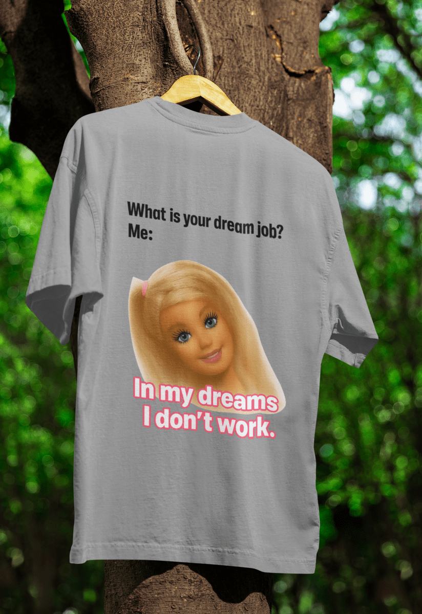 Graues T-Shirt mit Schriftzug Traumjob-Satire und Barbie-Portrait im Barbie-Meme-Stil fuer Anti-Work-Humoristen.