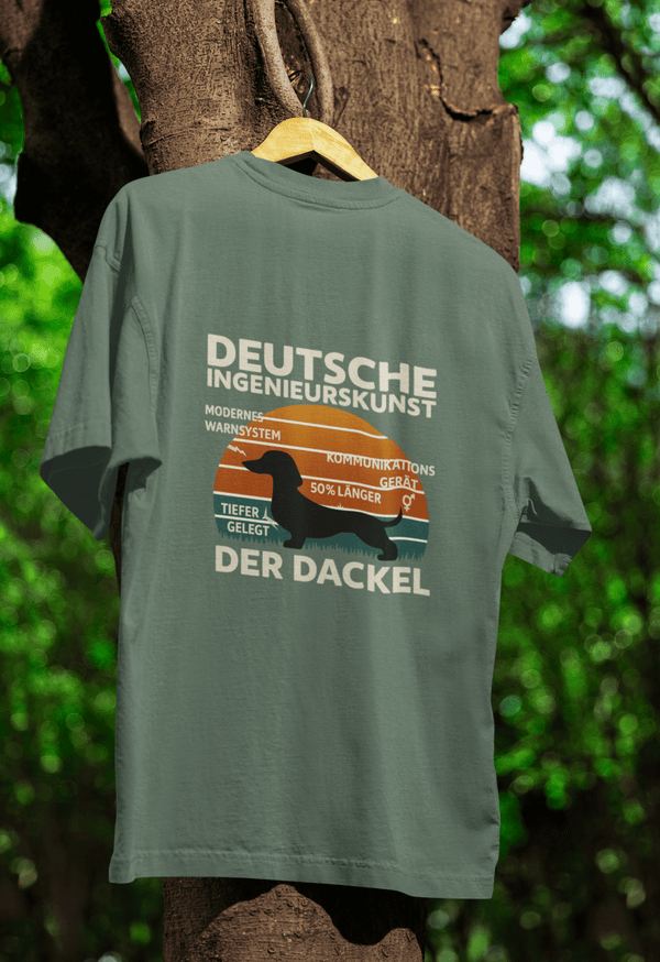 Graugrünes T-Shirt mit Schriftzug Deutsche Ingenieurskunst Der Dackel im Retro-Poster-Stil mit Dackel-Silhouette und Technik-Elementen für Hundefreunde und Satiriker.