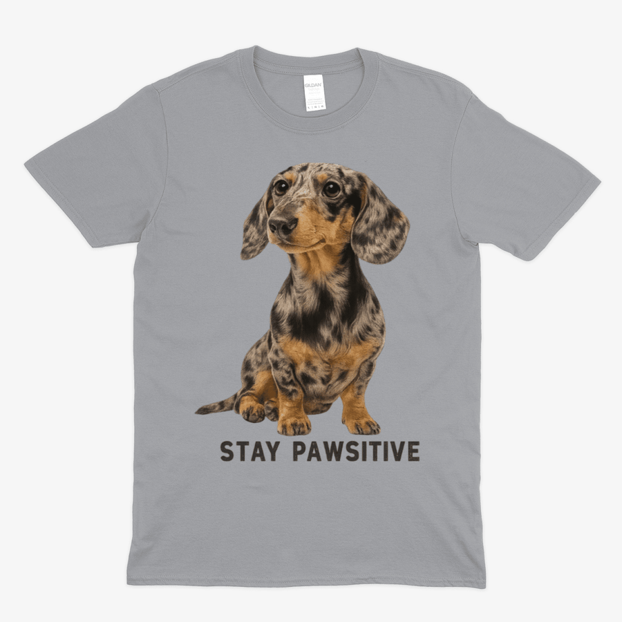 Graues T-Shirt mit Dackel-Motiv und Schriftzug Stay-Pawsitive im realistischen Fotografie-Stil für Hundeliebhaber.